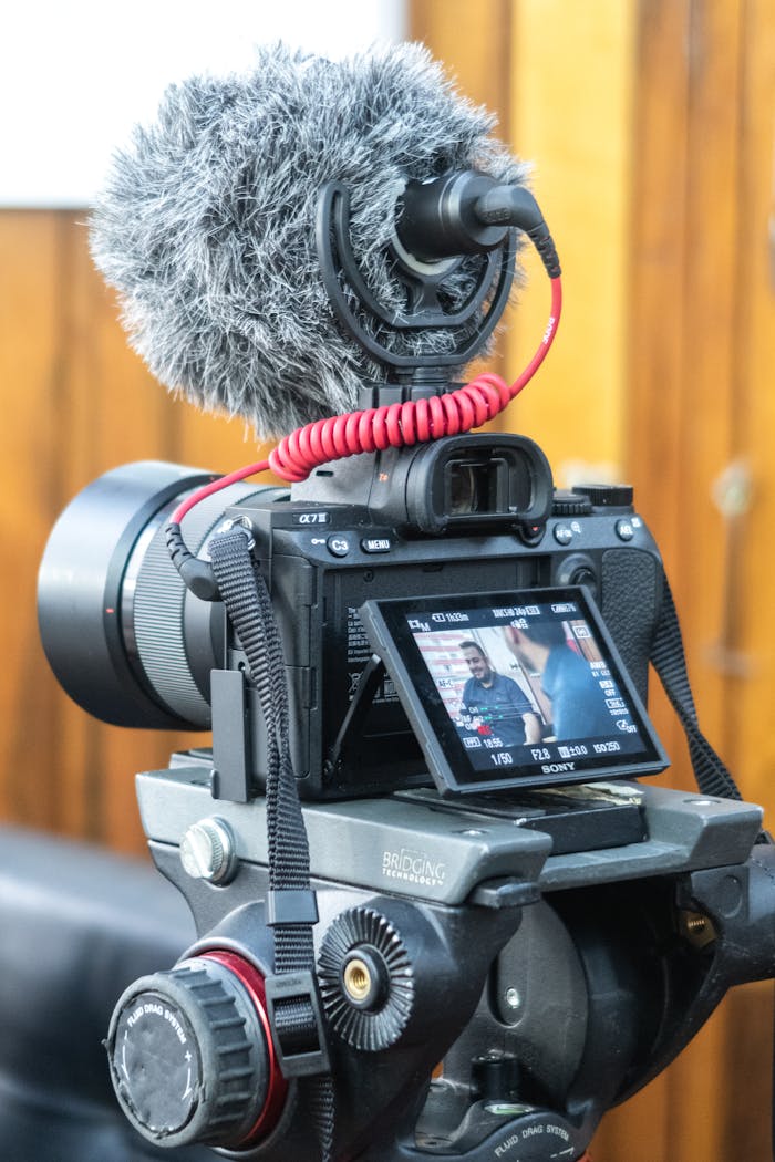 Mastering the First Impression: Your intriguing post title goes here Close-up of video camera with microphone setup indoors for filming.