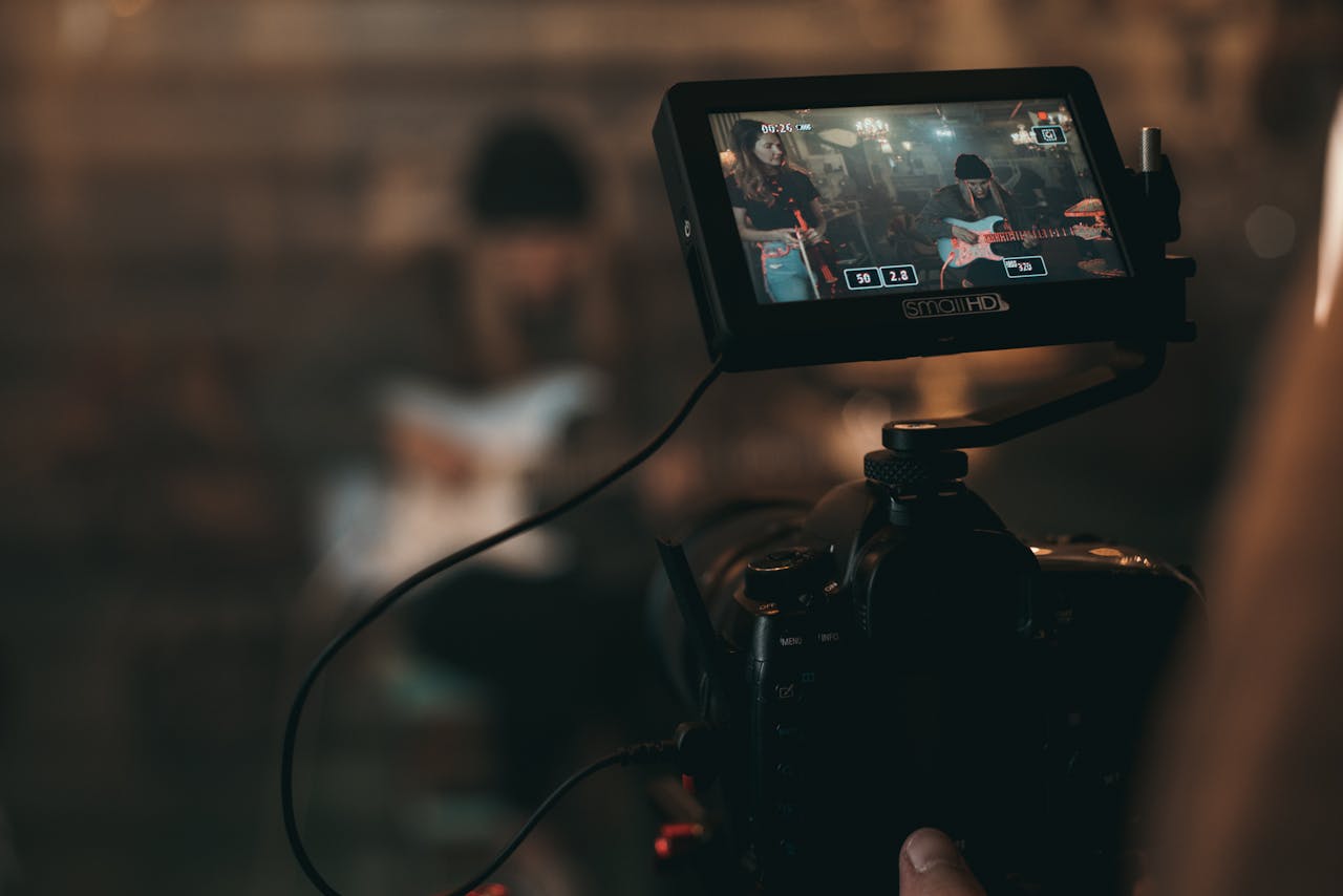 Crafting Captivating Headlines: Your awesome post title goes here A cinematic close-up of filming a rock band performance with focus on camera screen.